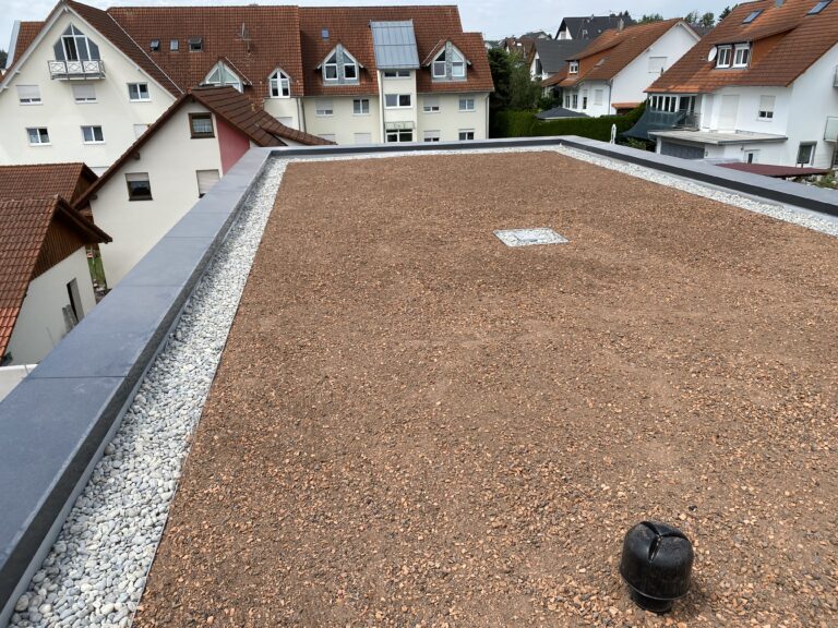 Flachdach mit Schüttung und Dachentwässerung auf einem Wohnhaus