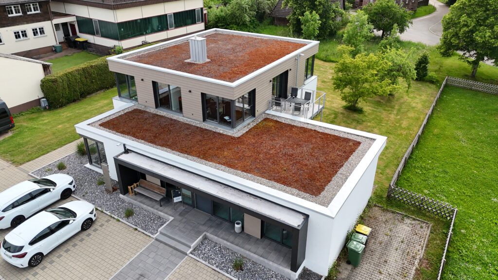 Modernes Wohnhaus mit mehreren Flachdächern, Luftaufnahme