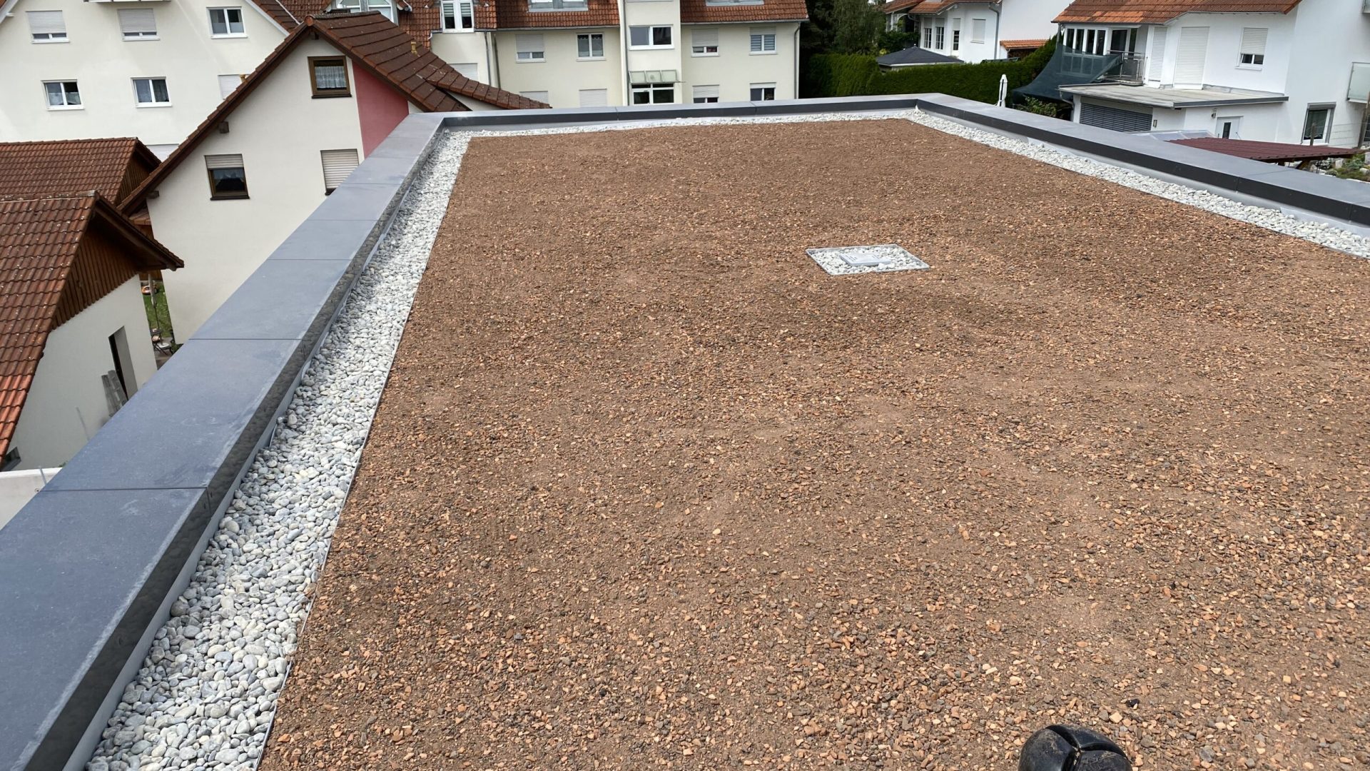 Flachdach mit Schüttung und Dachentwässerung auf einem Wohnhaus